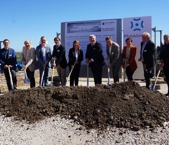 Eine Gruppe Verantwortlicher tätigen den ersten Spatenstich für den Erweiterungsbau im Jugendmaßregelvollzug