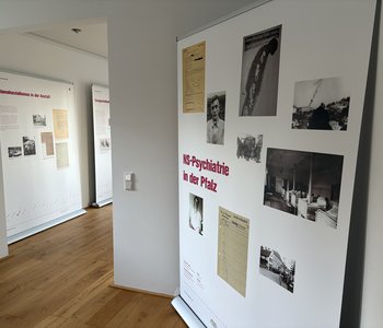Das Foto zeigt drei Tafeln der Ausstellung mit historischen Dokumenten und Infotext. Die erste Tafel trägt den Titel "NS-Psychiatrie in der Pfalz"